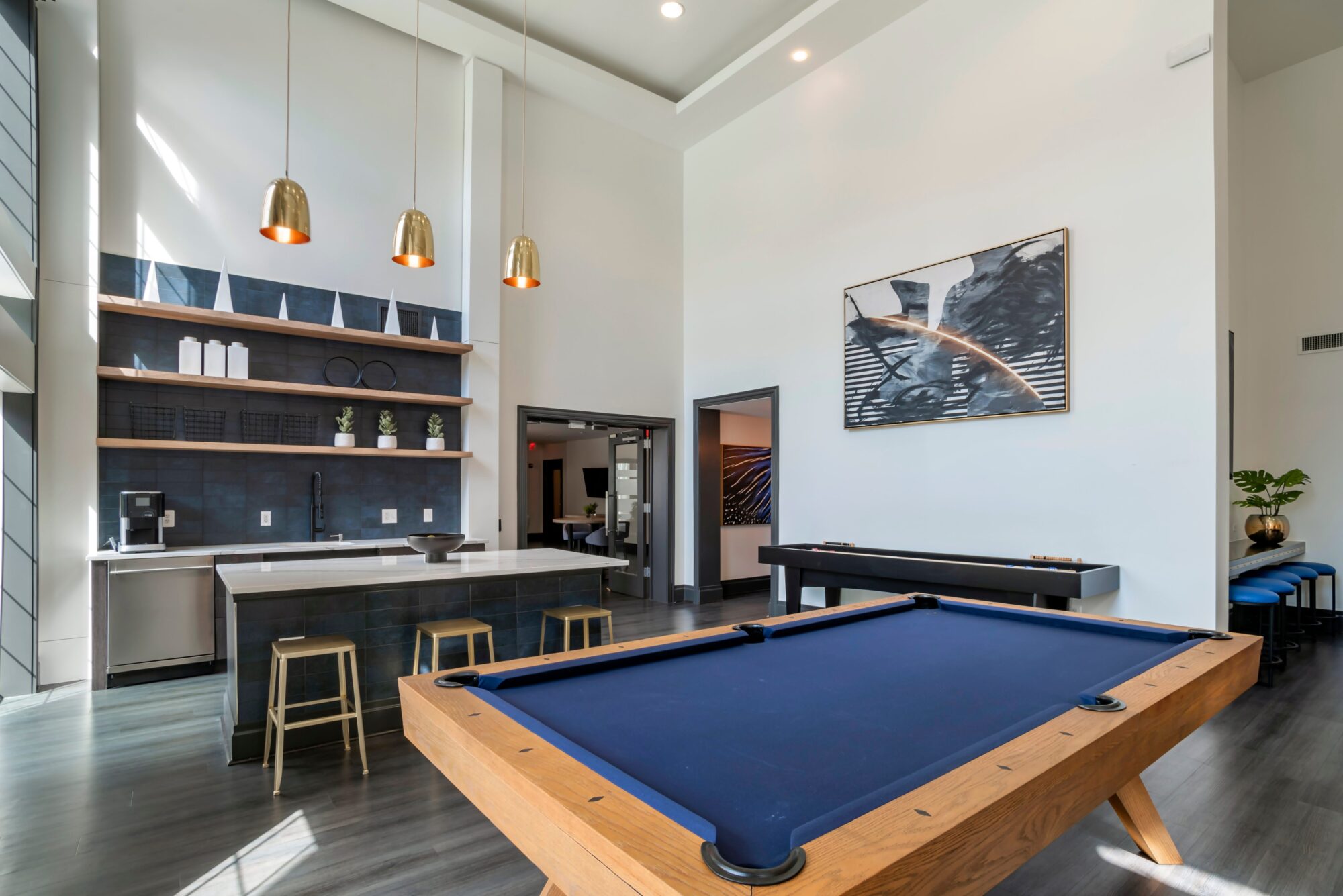 Clubhouse room with a kitchenette, coffee machine, dishwasher, billiards, bar seating, and shuffleboard