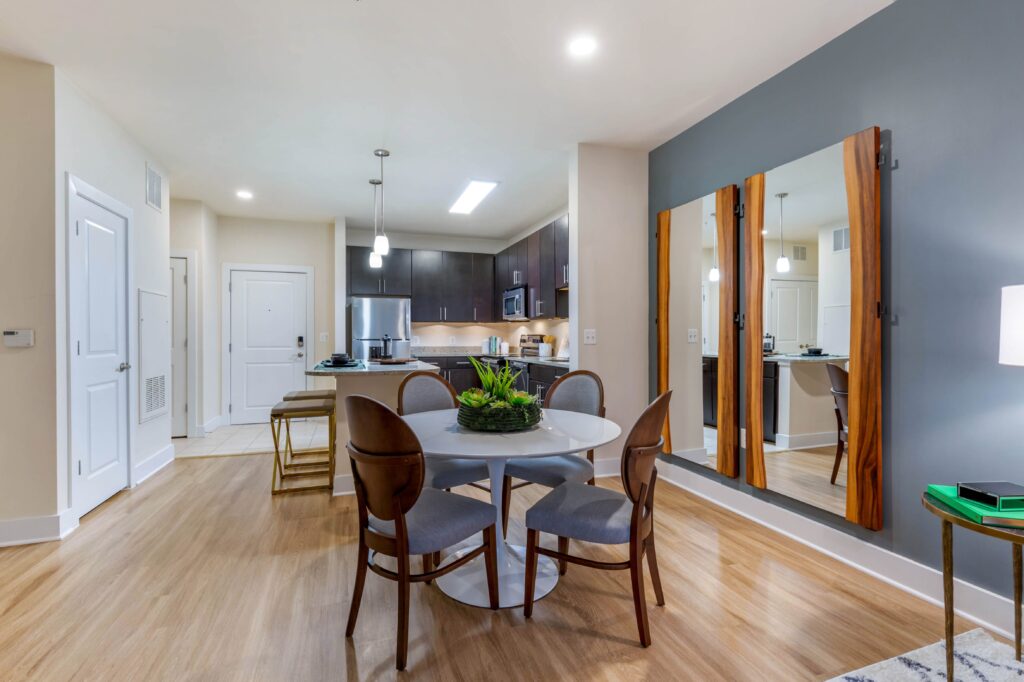 A kitchen and dining room with room for a 4 person table, and 2 person seating at the island bar.