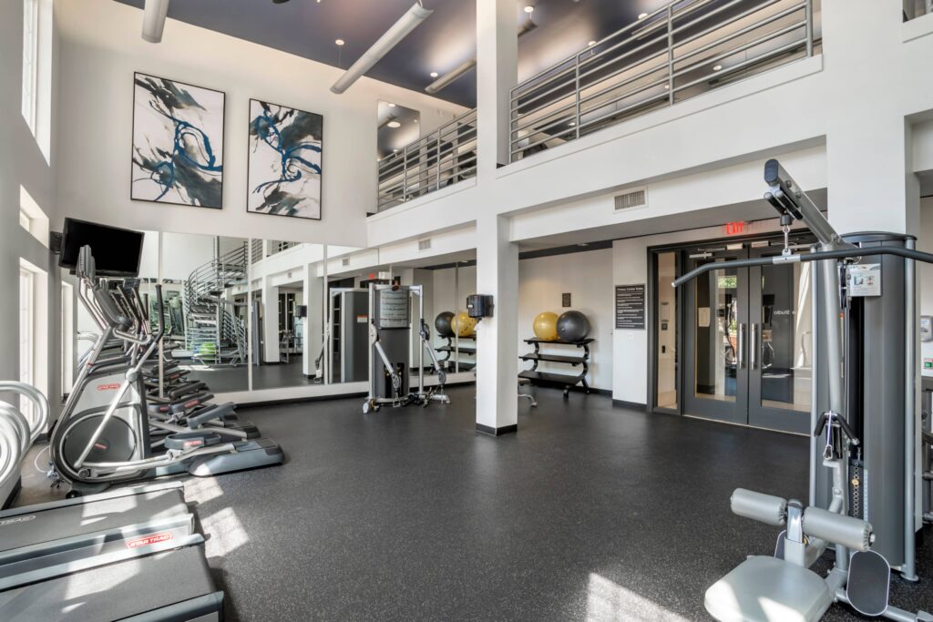 A 2 story gym with machines and medicine balls.