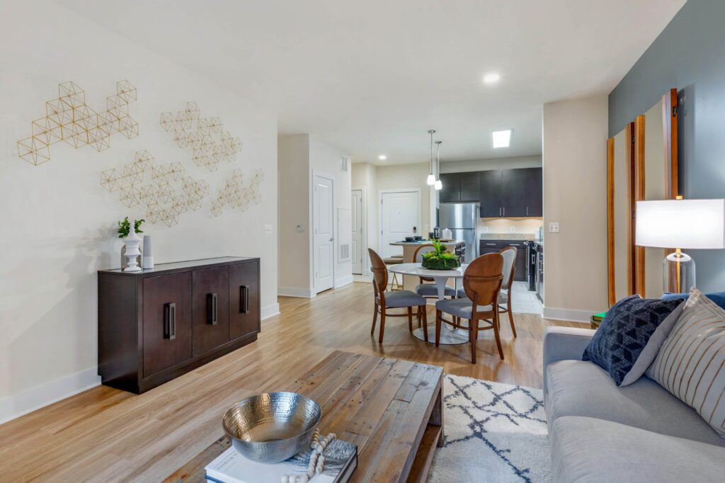 Open livingroom, dining, and kitchen with wood look floors, a blue accent wall, and modern fixtures and finishes